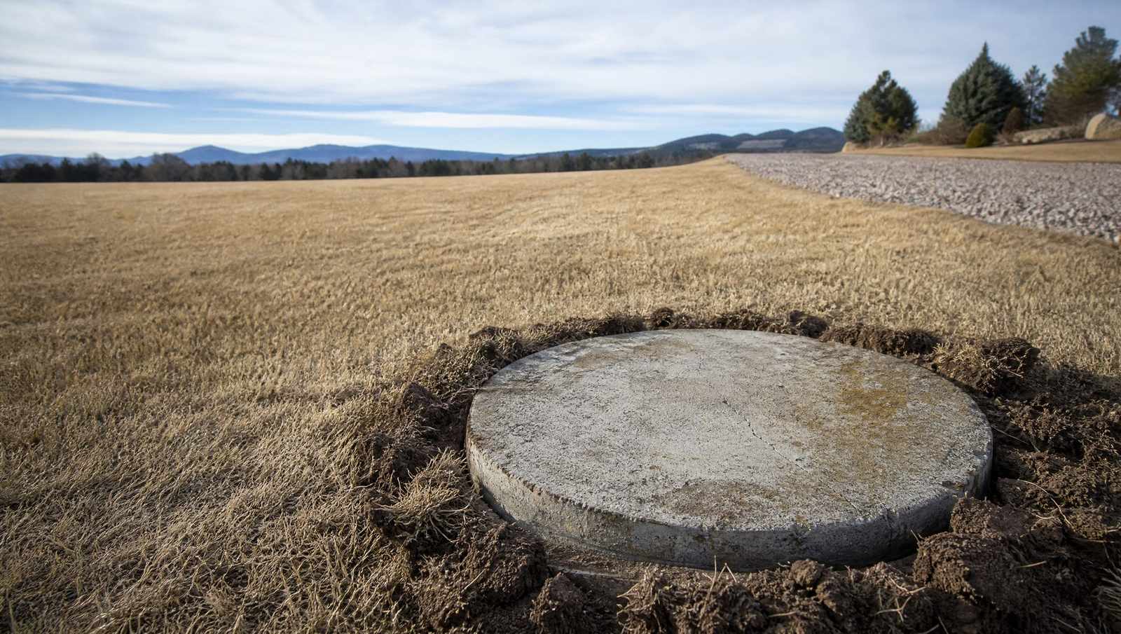 Weathered concrete septic tank lid uncovered in a dry Colorado Front Range lawn