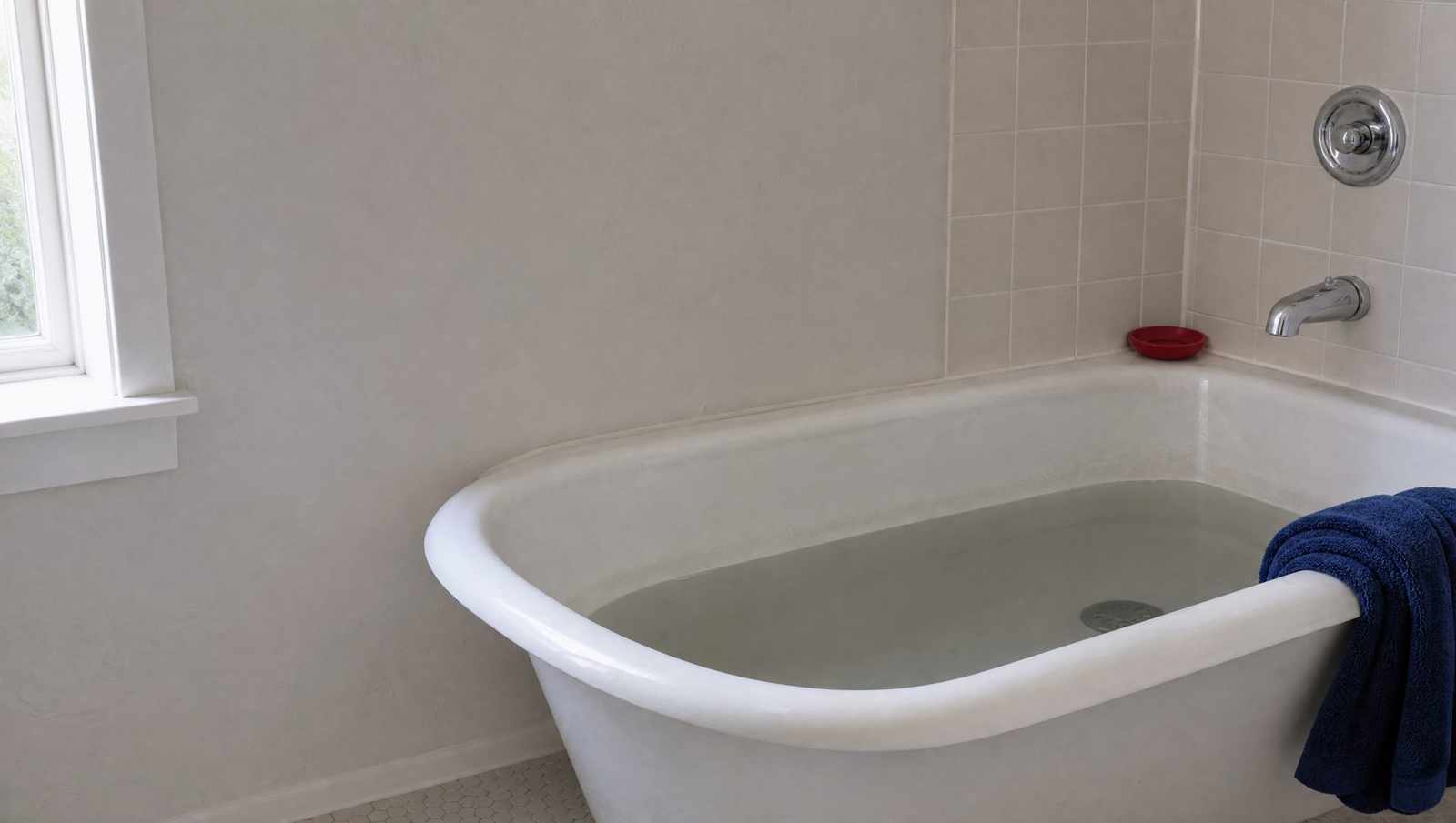 Cloudy water standing in a bathtub over a drain that will not clear